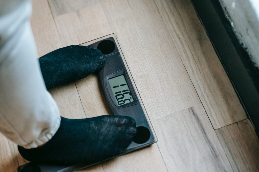 Person standing on a scale chceking their weight after a weight loss session